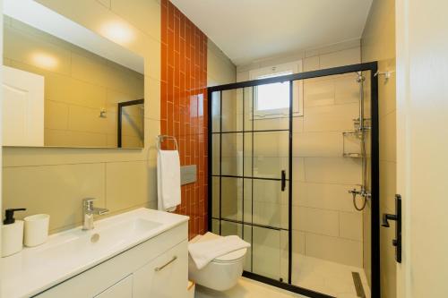 a bathroom with a shower and a sink and a toilet at Bluey Çalış Beach House in Fethiye