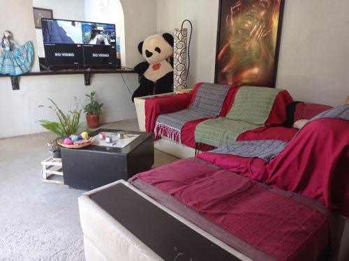 - un salon avec deux lits et un ours en peluche dans l'établissement Casa rústica, à Oaxaca