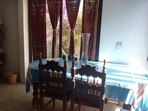 une table avec deux chaises devant une fenêtre dans l'établissement Casa rústica, à Oaxaca