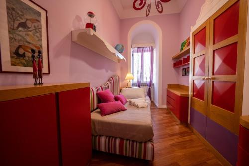 a room with pink walls and a couch with pink pillows at Casa Sofia Apt in Naples