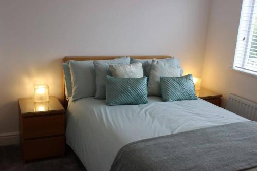 a bedroom with a bed with blue and white pillows at The White House in Wirral