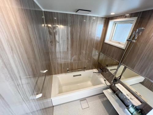 a bathroom with a bath tub and a window at Beach SPA TSUDA 2&3 - Vacation STAY 76782v in Sanuki