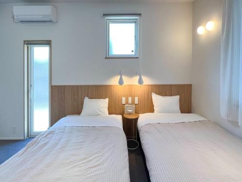 a room with two beds and a window at Beach SPA TSUDA 2&3 - Vacation STAY 76782v in Sanuki