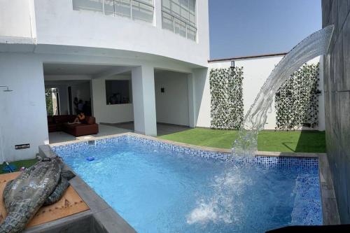 una piscina con una fuente en una casa en SunsetHouse tu lugar de descanso, en Punta Negra