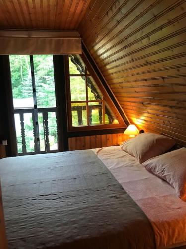 a large bed in a room with a large window at Ferienhaus am Mescheriner See in Mescherin