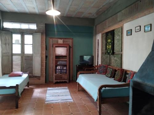 sala de estar con 2 camas y TV en Aldea Zen Chales Privativos, en Ouro Preto