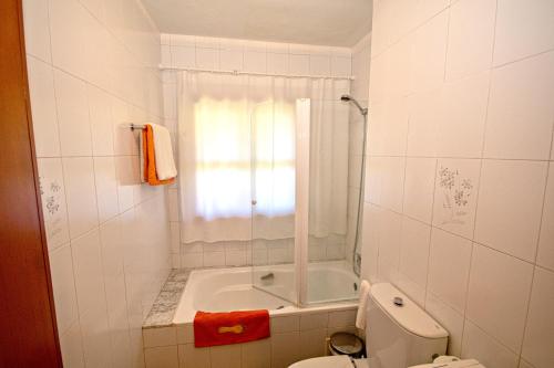 a bathroom with a shower and a toilet and a tub at 2 bedrooms appartement at Vilanova 100 m away from the beach with sea view enclosed garden and wifi in Aldán