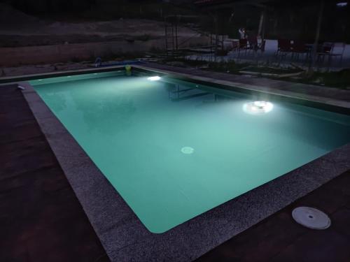 a swimming pool lit up at night with blue lights at Armada Sacra A Teixeira in Ourense