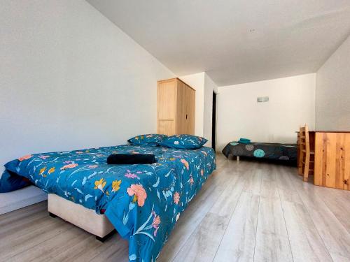 um quarto com uma cama com um edredão azul em Gorges du Verdon - Hyper centre Castellane - Rue Piétonne - Studio 3 Couchages em Castellane