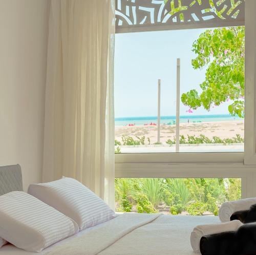 - une chambre avec une fenêtre donnant sur la plage dans l'établissement Mangroovy Seaview 3BR Beach and Pool Free access, à Hurghada