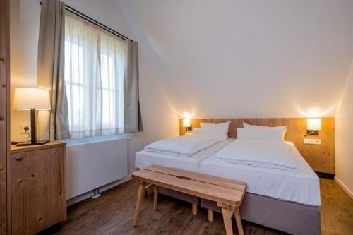 a bedroom with a large bed and a wooden table at Cottages, turf house in Torfhaus