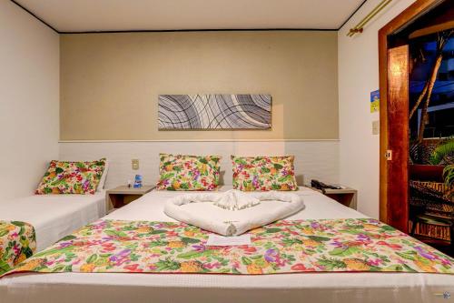 a bedroom with two beds with flowers on it at Pousada Praia Bela in Ilhéus