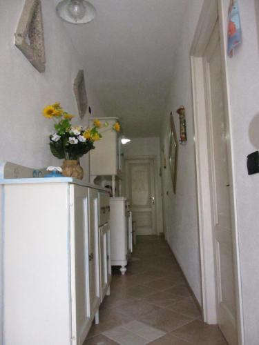 a kitchen with white appliances and a vase of flowers on a cabinet at Bed & Breakfast Mare Isole in La Maddalena