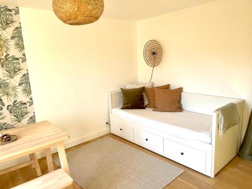 ein Zimmer mit einem weißen Bett mit Kissen darauf in der Unterkunft La Grange 1743 