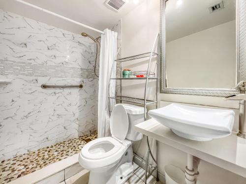 a white bathroom with a toilet and a sink at Hollywood by the Sea in Hollywood