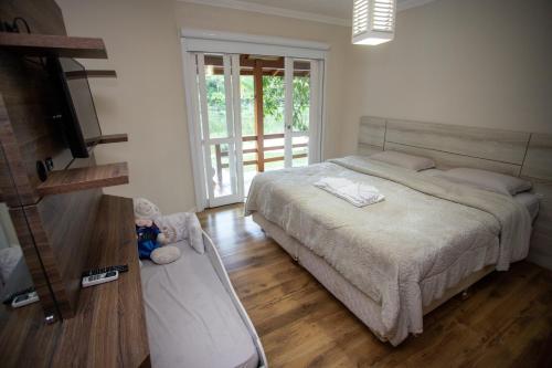 um quarto com uma cama grande e piso em madeira em Casa de Campo, Refúgio do Lago em Itajaí