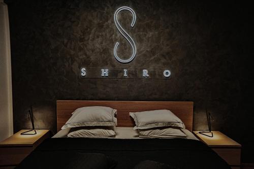 1 dormitorio con 1 cama con un cartel de sarma en la pared en Shiro HavenSuite, en Bucarest