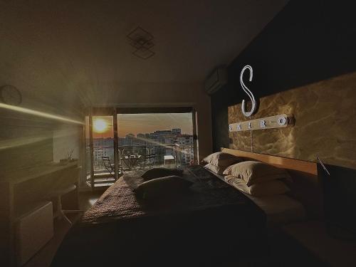 Un dormitorio con una cama y una ventana con vistas. en Shiro HavenSuite, en Bucarest