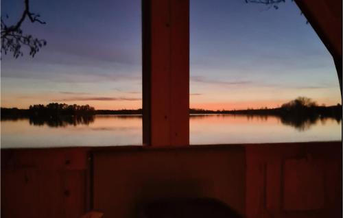 a window view of a lake at sunset at 3 Bedroom Awesome Home In Sävsjö in Gistingstorp
