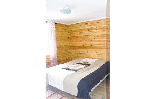 a bedroom with a wooden wall at Beautiful Home In Svsj With 3 Bedrooms And Wifi in Gistingstorp