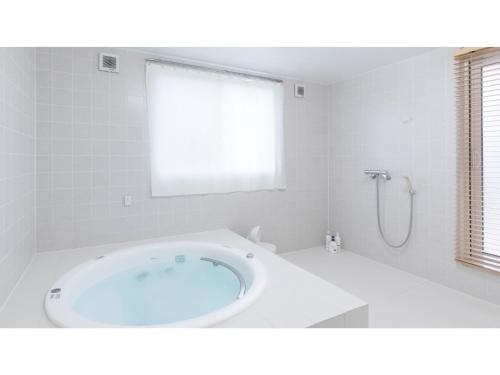 uma casa de banho branca com uma grande banheira num quarto em TEA TREES - Vacation STAY 86532v em Tateyama