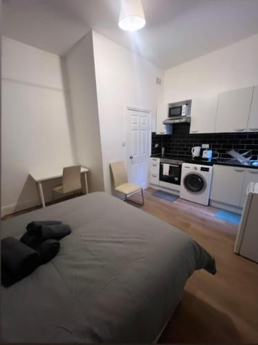 1 dormitorio con 1 cama grande y cocina en Private Self Contained Studio In The Heart Of Golders Green en Londres