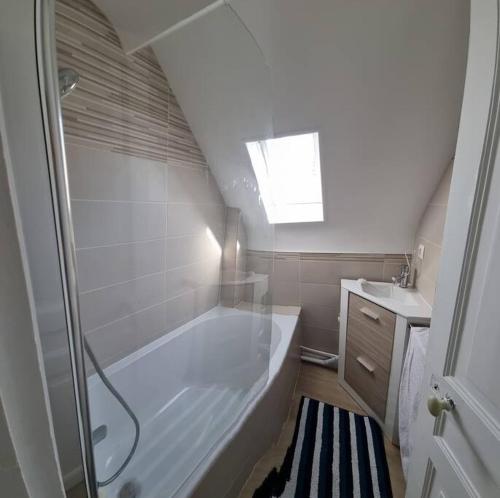 une salle de bain avec une baignoire et un lavabo dans l'établissement Villa Alcyon, à Lion-sur-Mer