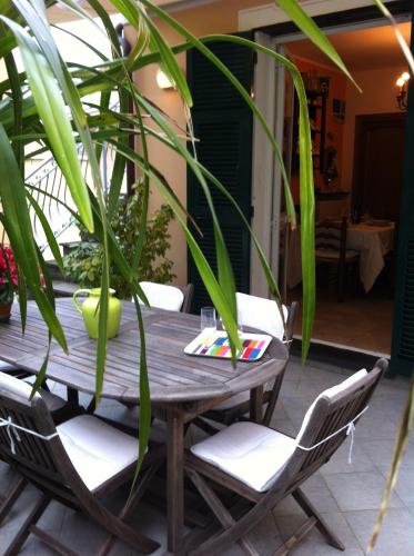 a wooden table with chairs and a plant at Ca D'Ancioa in Moneglia