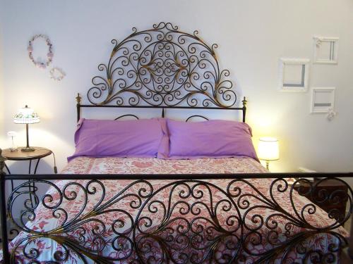 1 cama con cabecero de hierro forjado en un dormitorio en Ca D'Ancioa, en Moneglia