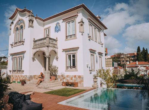 una casa con piscina frente a ella en The Salty Pelican Beach Retreat, en Monte Estoril