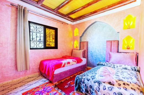a bedroom with two beds and a window at Riad imNane Lodge in Tamguist