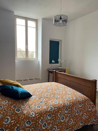 a bedroom with a bed with a blue pillow on it at le gite de Justine et Agathe in Verdun