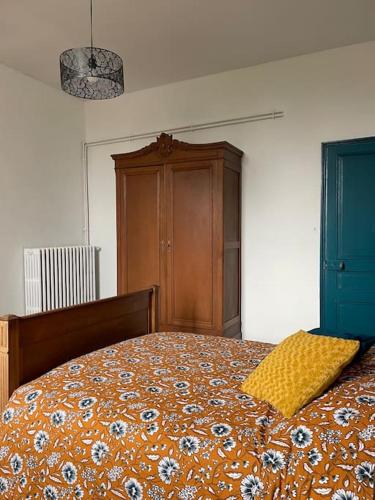 a bedroom with a bed with a yellow pillow on it at le gite de Justine et Agathe in Verdun