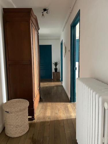 a hallway with a bed and a cabinet in a room at le gite de Justine et Agathe in Verdun