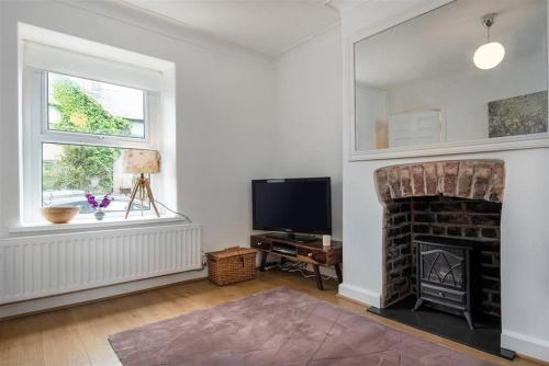 a living room with a fireplace and a tv at Lavender Terrace in Llandudno