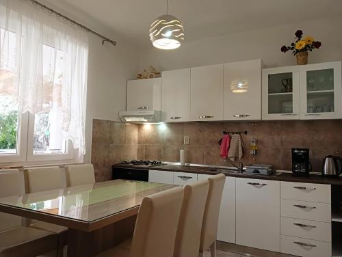a kitchen with white cabinets and a glass table at Villa Ivan in Dubrovnik