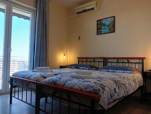 a bedroom with two beds and a large window at Villa Ivan in Dubrovnik