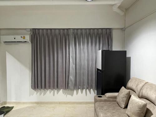 a living room with a couch and a curtain at Mall Suites Hotel in Bangkok