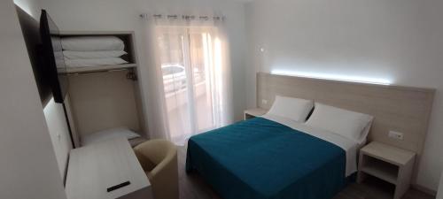a small bedroom with a bed and a window at Appartamento Parco Urciuolo Cirella in Cirella