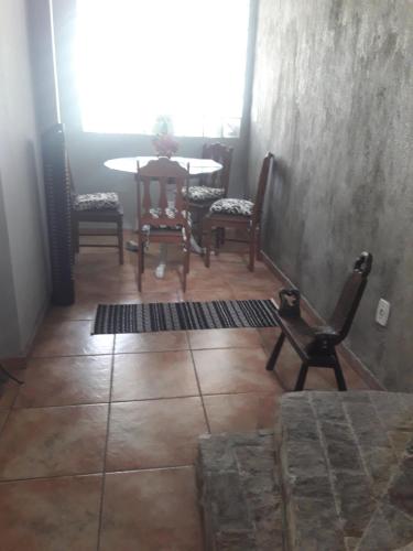 een kamer met stoelen, een tafel en een raam bij Bedroom near Forest in Rio de Janeiro