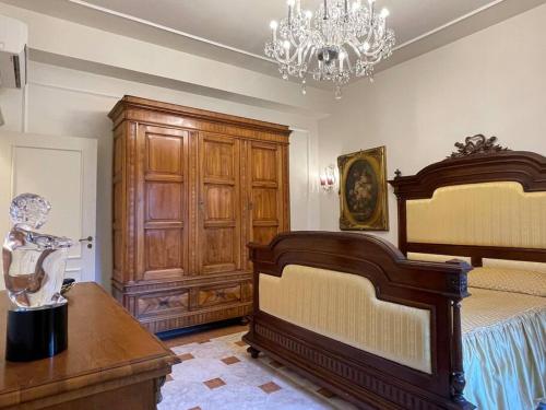1 dormitorio con cama y lámpara de araña en Fancy House, en Reggio Calabria