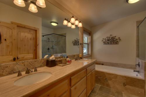 W łazience znajduje się umywalka, lustro i wanna. w obiekcie Brand New Upscale Home, Hot Tub, Foosball w mieście South Lake Tahoe