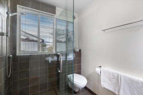 a bathroom with a toilet and a glass shower at Lake and Mountain view living in Queenstown