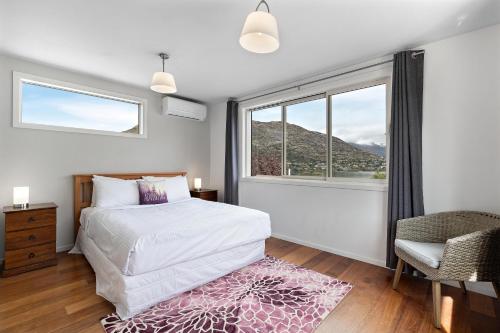 1 dormitorio con cama y ventana grande en Lake and Mountain view living en Queenstown
