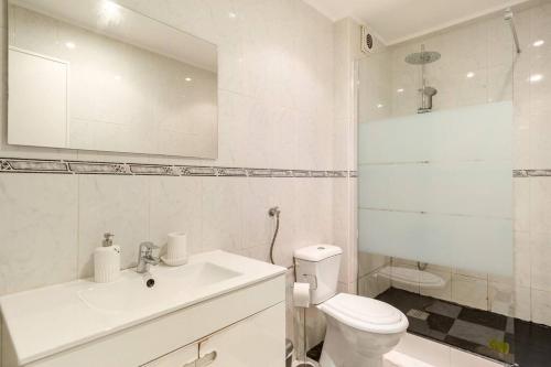 a white bathroom with a sink and a toilet at Cantinho do Sossego de Agualva-Cacém in Agualva