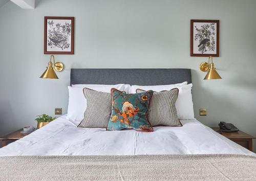 a white bed with two pillows on it at The New Inn Heckfield in Hook