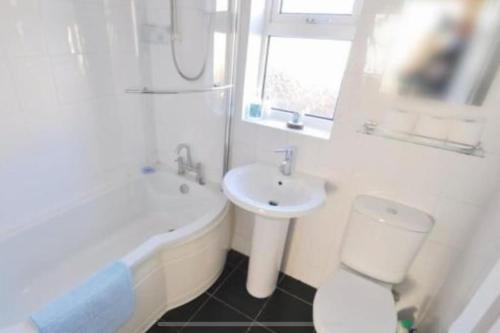 ein weißes Badezimmer mit einem Waschbecken, einem WC und einer Badewanne in der Unterkunft Tivoli villas in New Brighton