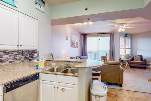 a kitchen with a sink and a living room at Shores of Panama 2310 in Panama City Beach