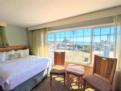 a hotel room with a bed and a large window at Seaway Inn in Santa Cruz