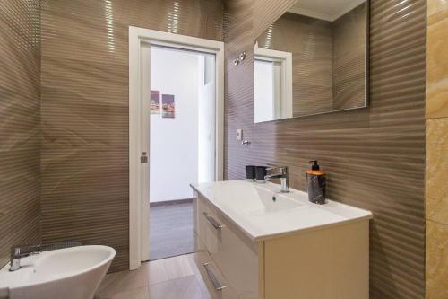 a bathroom with a sink and a toilet and a mirror at Casa Viveiros do Bairro Penha de França Lisboa in Lisbon